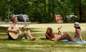 young nude people relaxing on the grass in a park