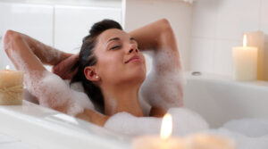 woman taking bubble bath with candles